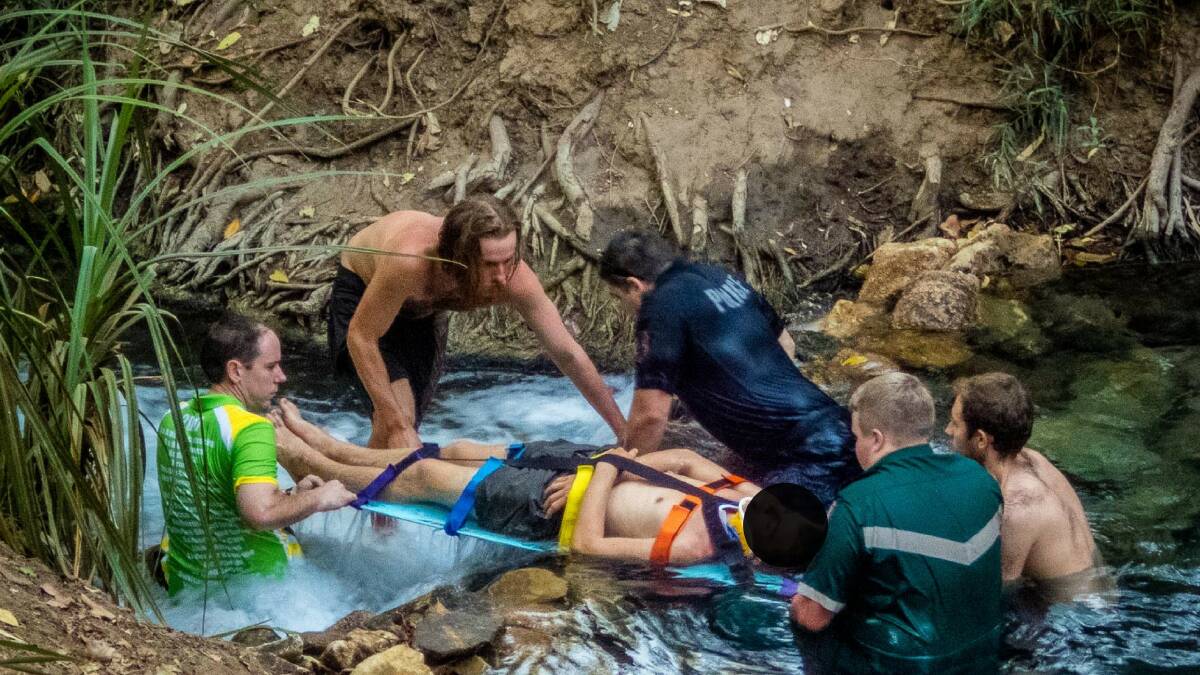 SPRINGS RESCUE: Paramedics and the man's mates help float the badly injured backpacker down the popular Katherine tourist attraction. Picture: Brian Dean.