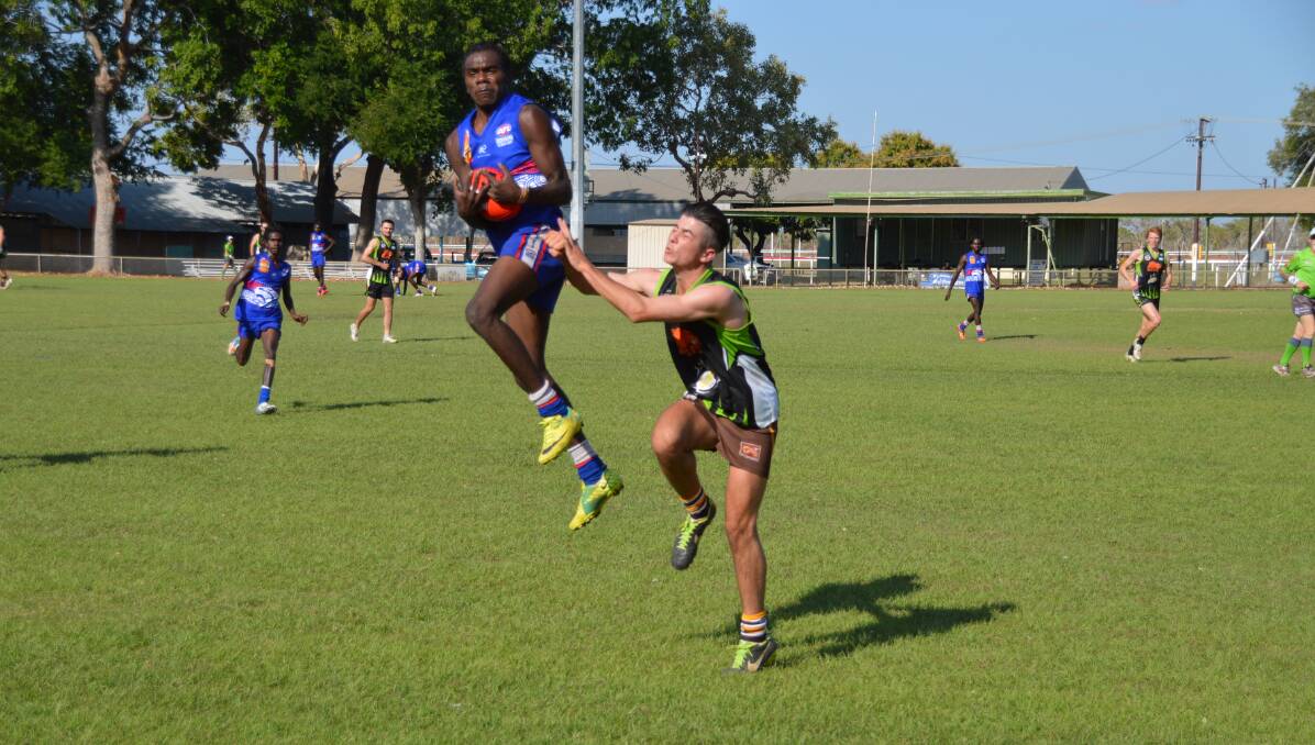 AIR UP THERE: Sylvester Wurramurra gets the jump on his Katherine Camels opposite number as the Ngukurr Bulldogs star takes a big mark.