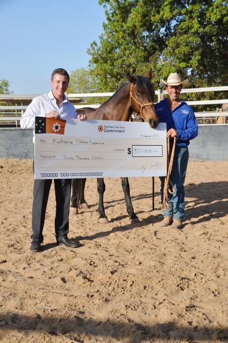 Member for Katherine Willem Westra van Holthe gets some four-legged help presenting a $30,000 tourism grant to Tom Curtain on September 18.