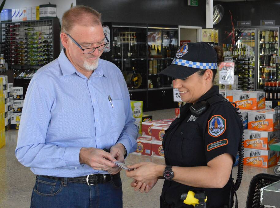 Police Minister Peter Chandler shows his identification to Aboriginal Community Police Officer Kim Emery during a tour of Katherine temporary beat locations on August 20. 