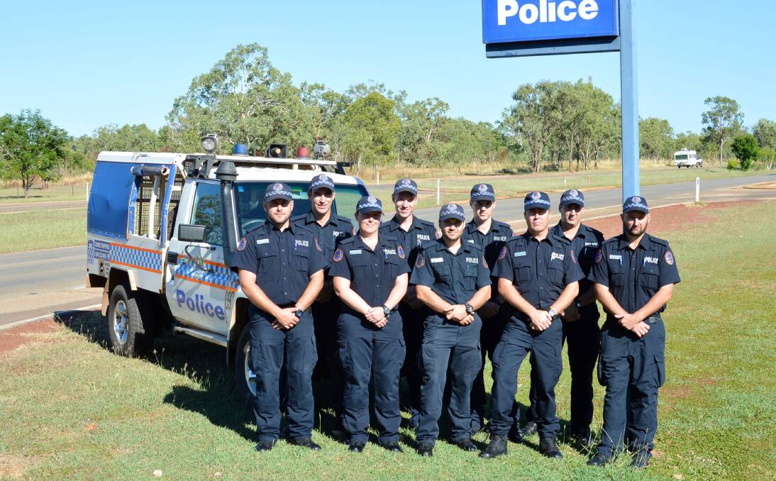 HITTING THE BEAT: Nine of Katherine's 10 new probationary constables - part of Squad 128 - get familiar with their new home as they pose for a group photo beside the Stuart Highway on their first day on the job on May 23.