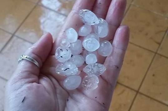 UNUSUAL OCCURRENCE: Shadforth Road resident Carolyn Adam shows off some of the hailstones that fell during a wild storm in Katherine on Saturday afternoon.