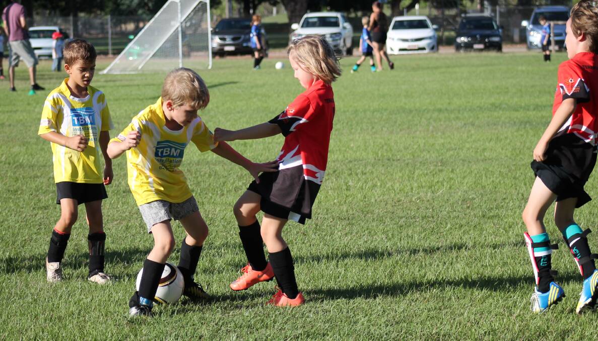 POWERFUL DEFENCE: Redback's Elouise Thomas works hard to get the ball off Light Dragon's Archie Howard during the teams' under-9 Katherine Football Club clash on May 21.