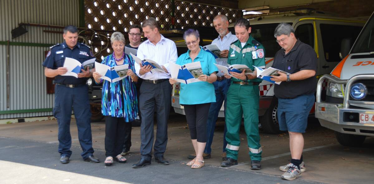 FLOOD FUTURE: Members of the flood advisory committee and St John Ambulance NT officer-in-charge Rhys Dowell inspect the final report.