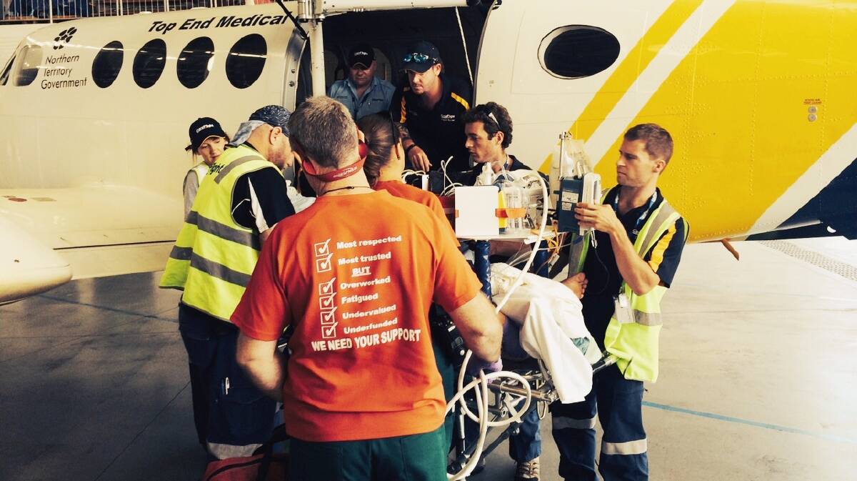 TAXI TRAUMA: Emergency services crews assist with loading a Katherine taxi driver onto a CareFlight aircraft for transporting to Royal Darwin Hospital after the 38-year-old was allegedly assaulted while working on August 30.