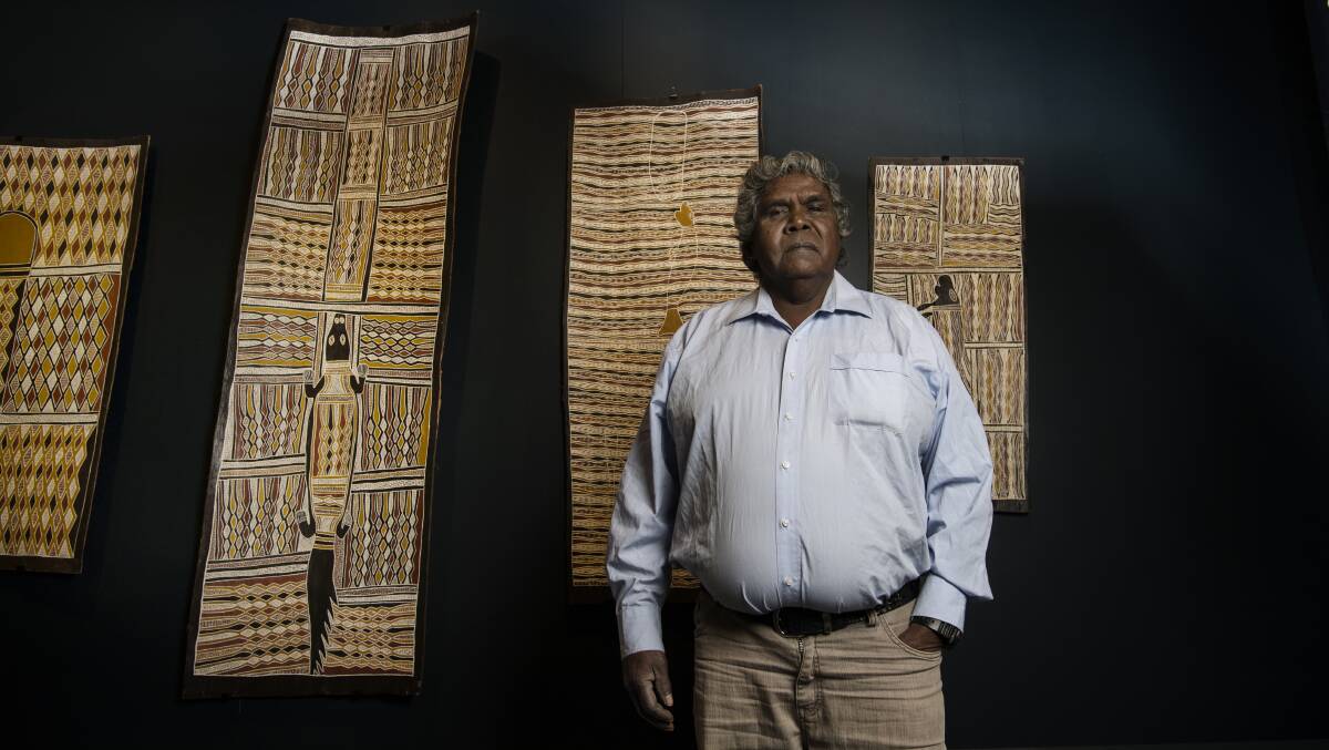 Djambawa Marawili with artworks by himself, his brother and his father. Photo: Louise Kennerley