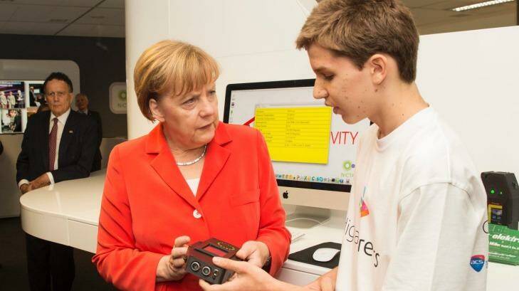 Michael Schultz shows his tricoder to German Chancellor Angela Merkel. Photo: NICTA