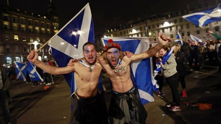 Supporters from the "Yes" Campaign wave Scottish Saltire flags in central Glasgow September 18, 2014. Polling stations closed in Edinburgh on Thursday evening after a day of voting in an historic referendum on Scottish independence. Photo: Reuters