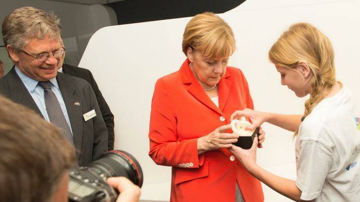 German Chancellor Angela Merkel tries out Esther Schulz's mood light as NICTA CEO Hugh Durrant-Whyte looks on. Photo: NICTA