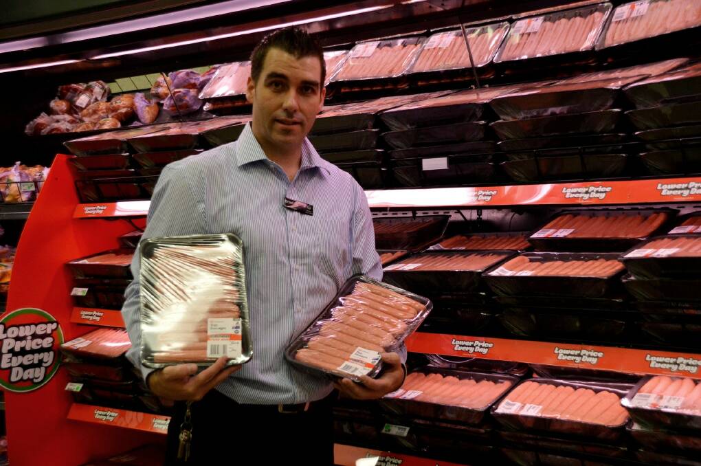 SNAGS IN THE BAG: Woolworths Katherine store manager Brad Darcy celebrates the sausage win.