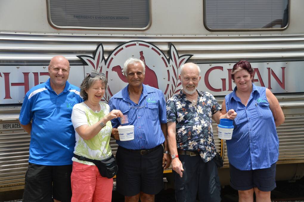 Wynyard Bus Lines staff Kirk Tracey, Ned Singh and Maxine Pitson grab a donation from German tourists Regina and Frohn Hansgeorg before they board the Ghan.