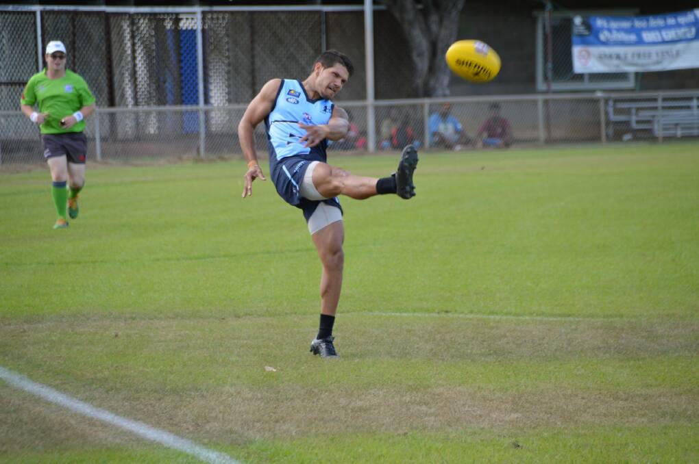Marcus Hamilton sends a kick towards Eastside's forwards during the first quarter at Nitmiluk Oval.