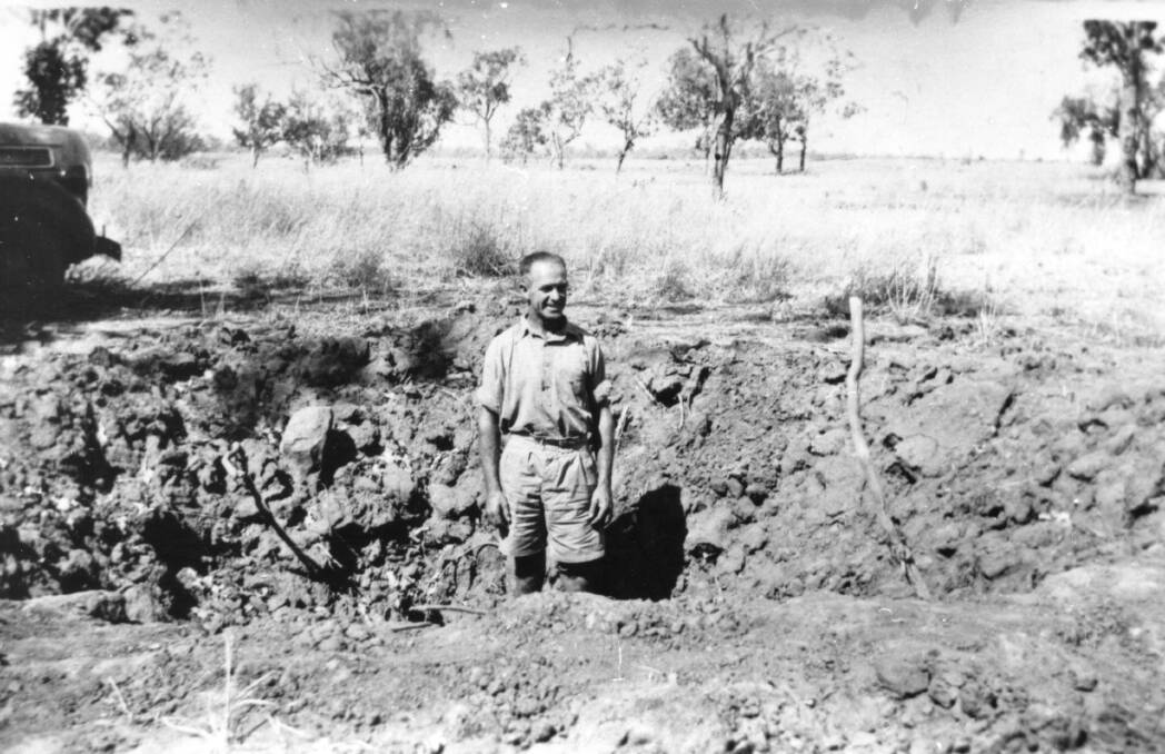 LEAVING A MARK:  PMG linesman Jack Corbell stands in the crater at the gallon licence store following the bombing of Katherine on March 22, 1942. Photo: KATHERINE HISTORICAL SOCIETY