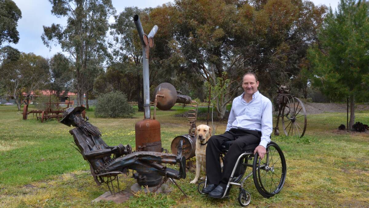 WELDER: Mr Connor with Buddy the dog hanging out with one of his many metal work scultpures. Picture: ALISON FOLETTA