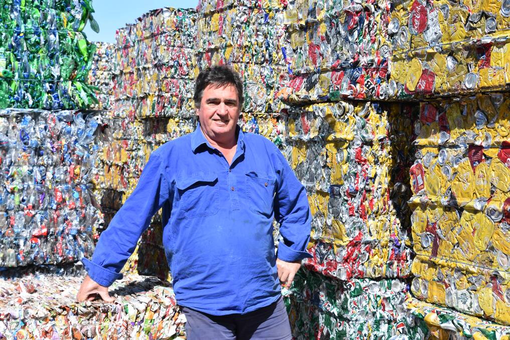 M.T Bins owner Michael Knight stands with six pallets of crushed cans, a small portion of the whole collected since 2012. 