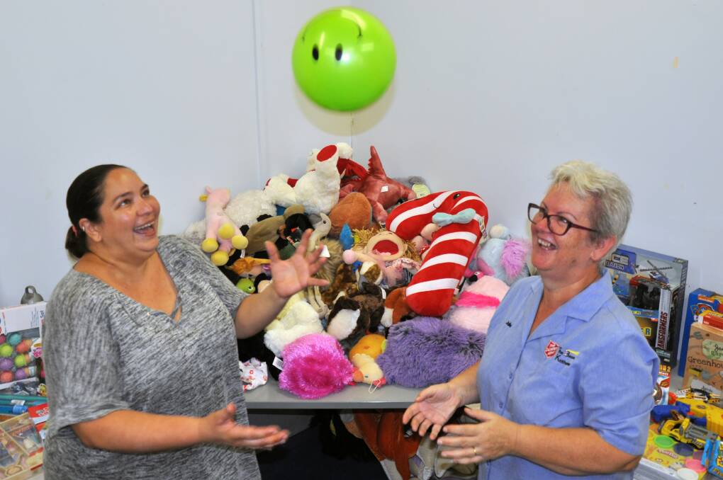 GIFTS GALORE: Family support worker at the Katherine Salvation Army, Amelia Harvey and Salvation Army Captain, Julie Howard have fun with the many gifts collected. 
