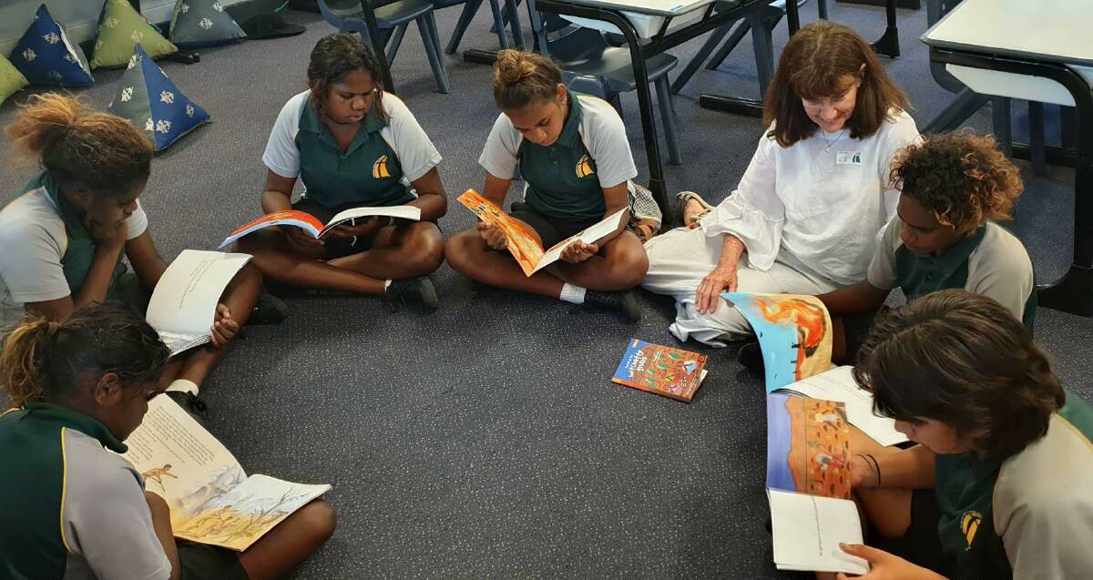 LEARNING TO READ: Year seven students Jasmine Jimmy, Lena George, Adele Godfrey, Cemiriah Green, (author) Margaret James, Elicko John and Tristian Lukanovic-Wilson enjoying reading the books from the Reading Tracks series. Picture: Linda Parkes. 