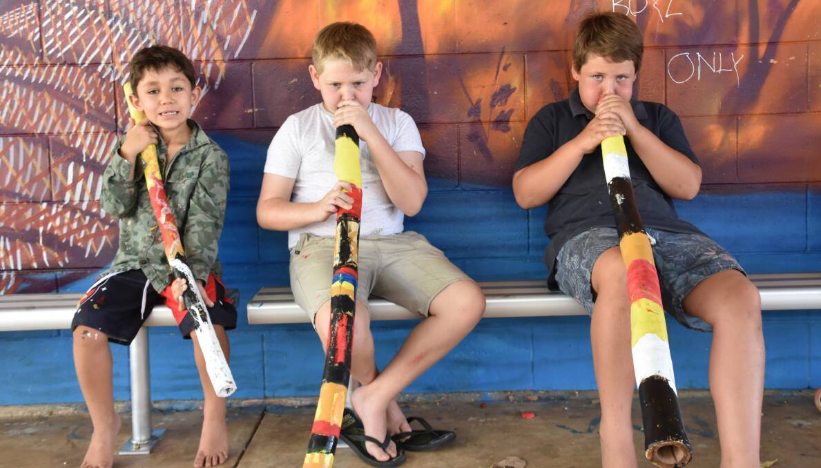 COMPLETED: Having finished making their didgeridoos, Lindsay, Braxton and Harrison are working on playing the instrument. 