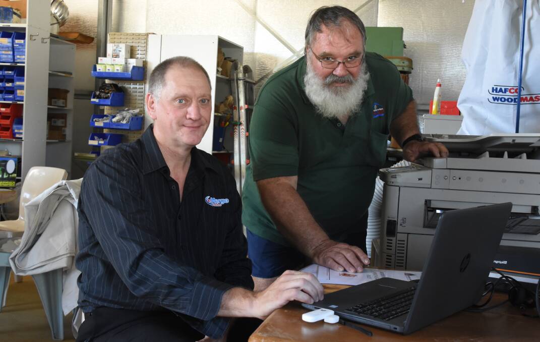 GENEROUS: NT Technology owner Kevin Grey shows vice president of the Men's Shed, Bryan Walters how to use his newly donated equipment. 