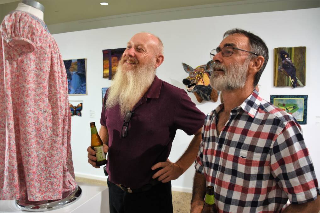 Peter Gazey and Geoff Newton take in the art. 