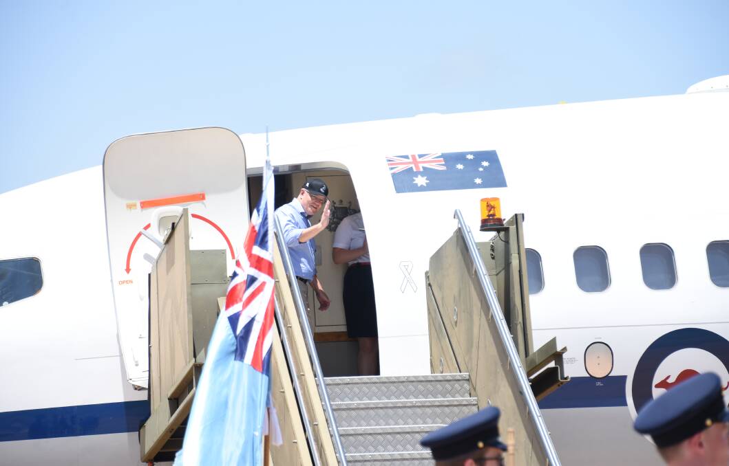 Mr Morrison waves goodbye as he boards the jet bound for home.
