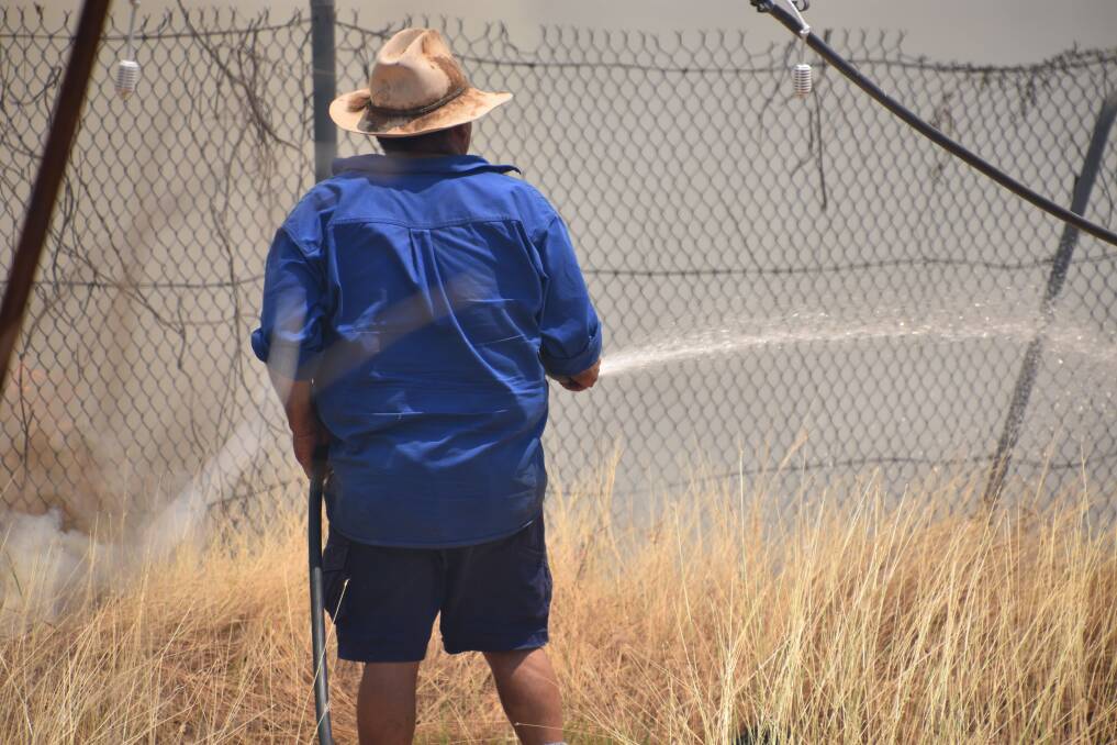 Members of the community have been called in to help firefighters control a fire near the Katherine Golf Club. 