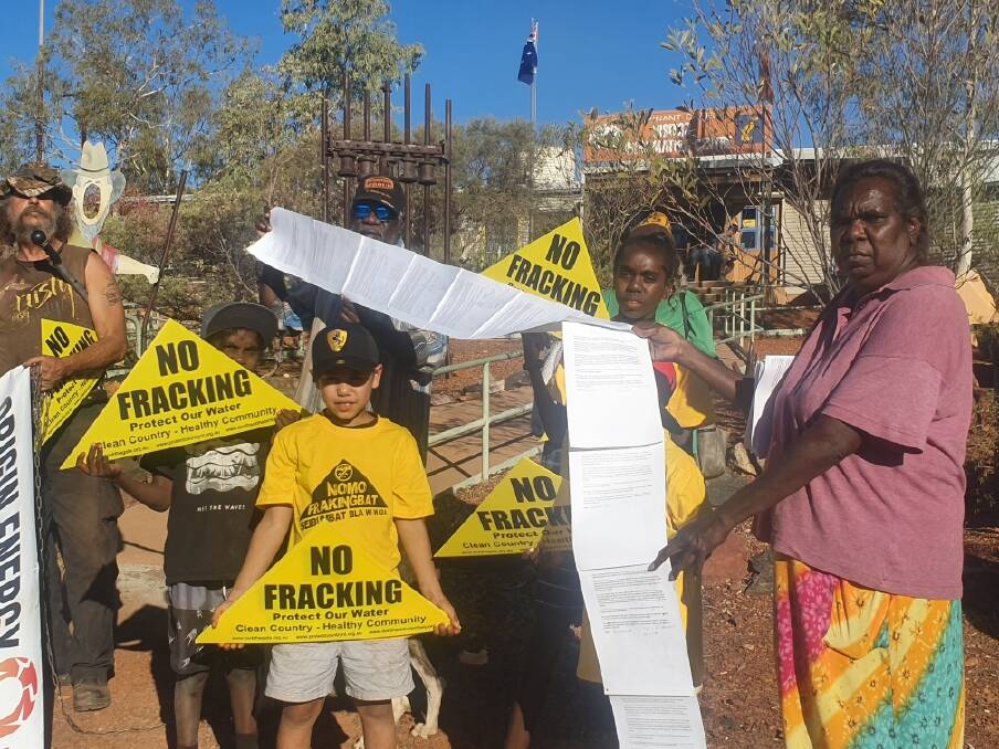 BANNED: Outside Origin Energy's fracking meeting in Tennant Creek this week, community members hold a list of signatures from more than 200 Traditional Owners who say they have not been consulted about fracking plans. Picture: Supplied. 
