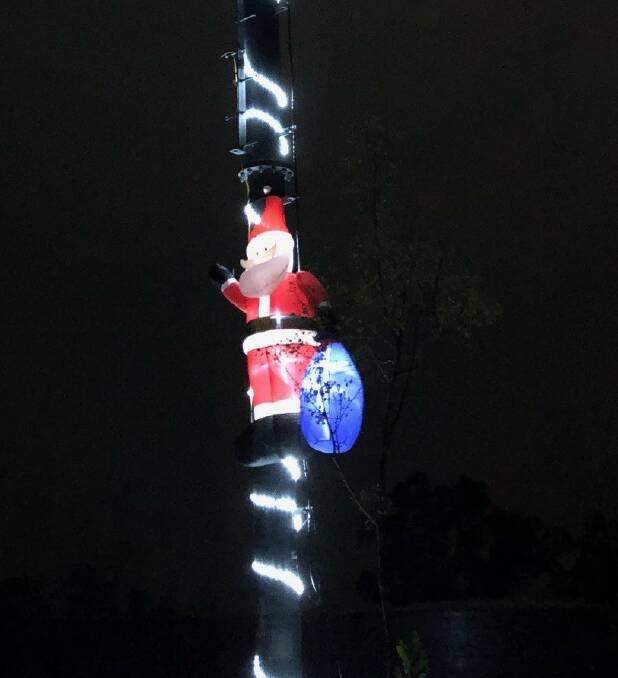 Santa appears to be climbing the pole towards the tree to place his presents. Pictures: supplied.