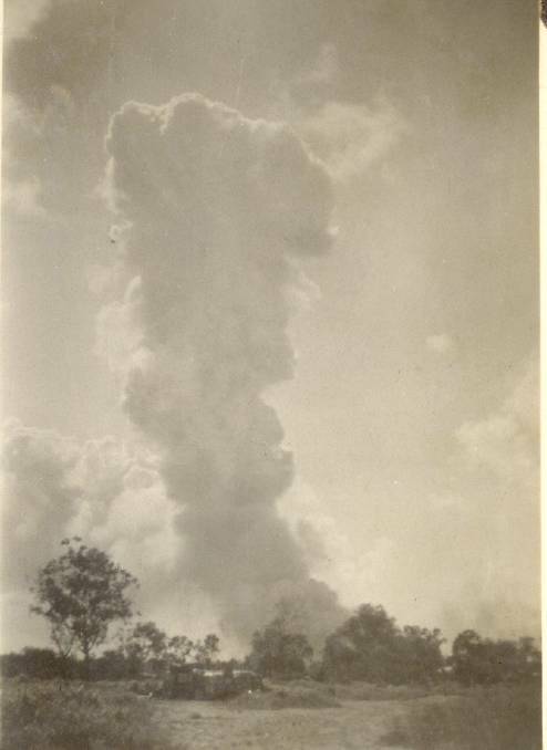 BOMB DAMAGE: A smoke cloud rises over Katherine after the raid. Picture: Katherine Historical Society.
