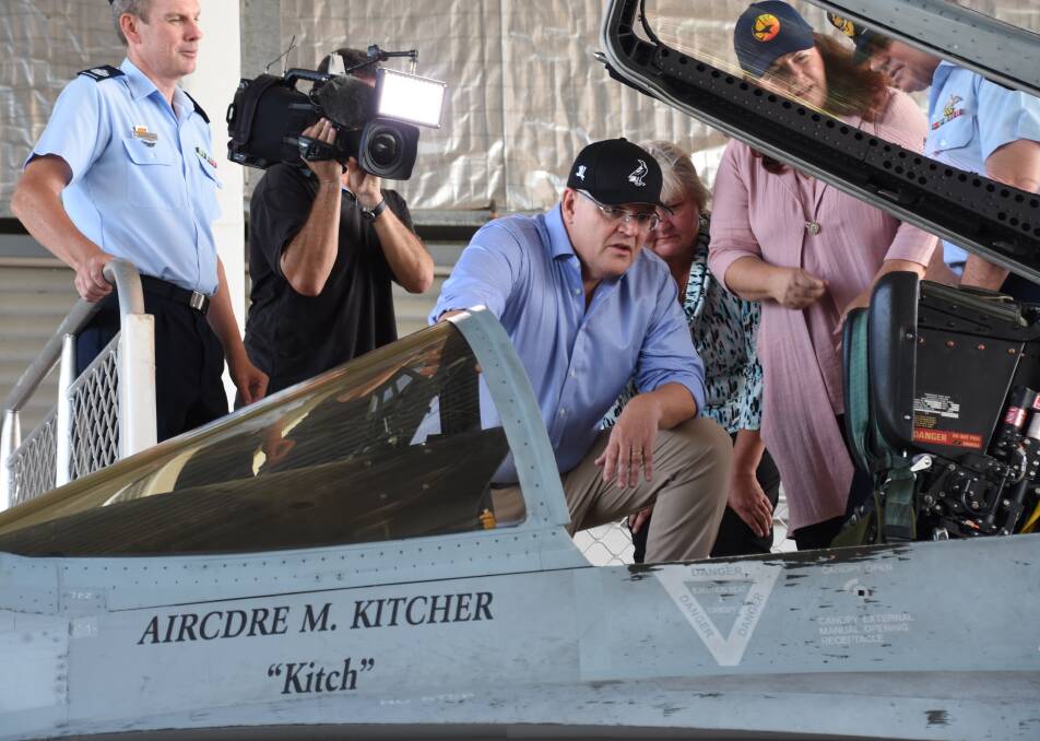 CHECK IT OUT: Prime Minister Scott Morrison checks out one of the ageing Hornets to be replaced in coming years by the Joint Strike Fighter at the RAAF base on Friday. Picture: Roxanne Fitzgerald.