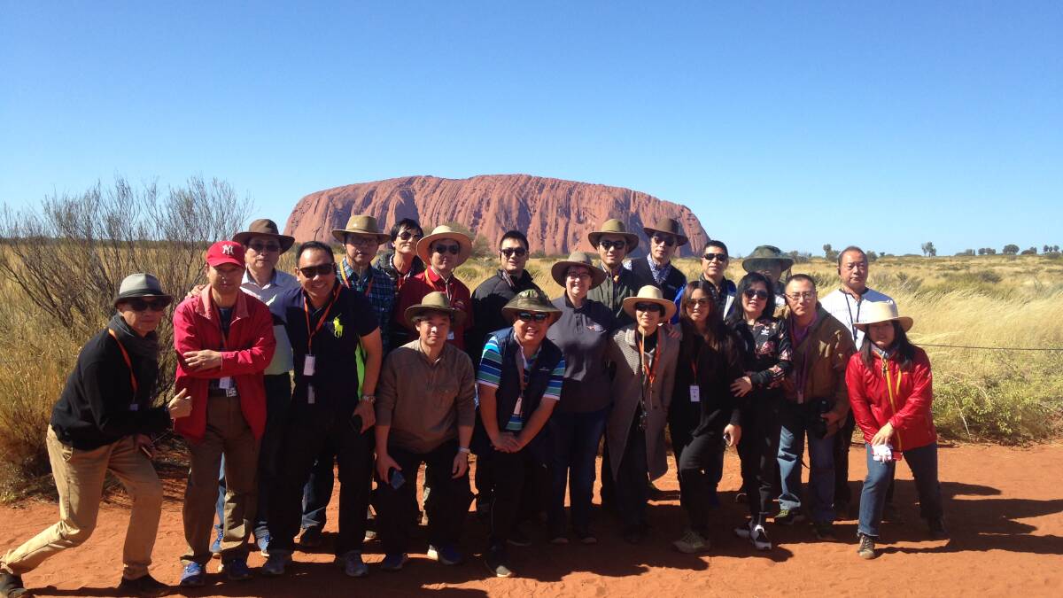 Mandarin speaking guides with Uluru in the background. Picture: NT Government.