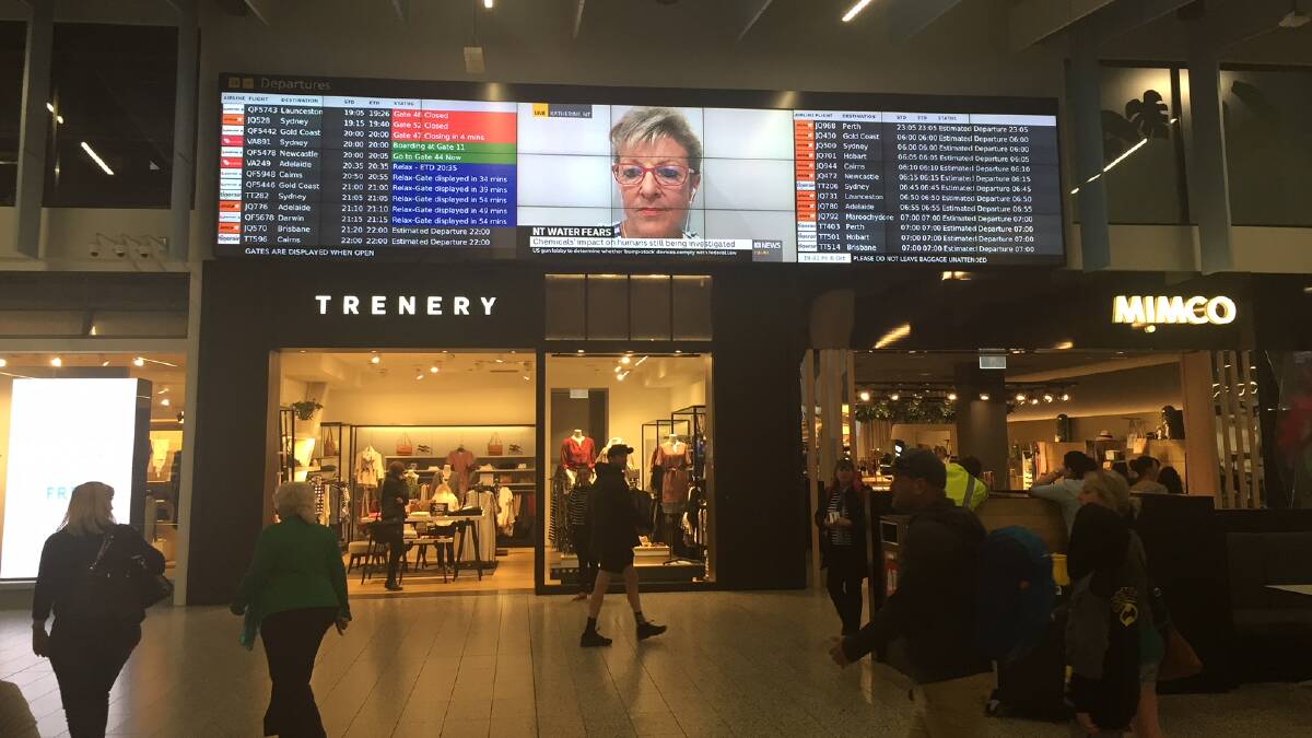 TOURISM DILEMMA: Katherine Mayor Fay Miller on the big screen with bad news for Katherine at Melbourne's Tullamarine airport on Friday night. Picture: Chris McLennan. 