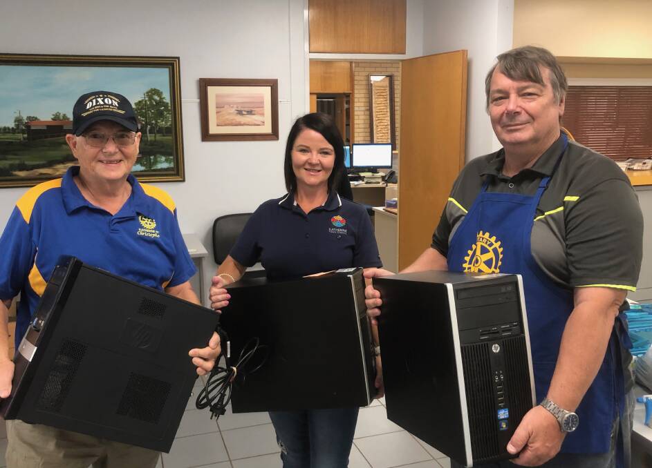 Rotarians Chris and Andrew gratefully accept the donation of surplus computer towers from Katherine Town Council's Kira Collie.