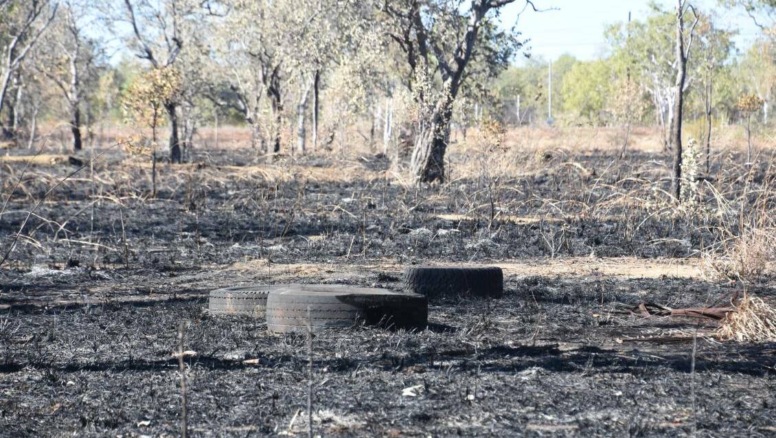 A fire swept through grass and shrub next to the busy Bicentennial road before reaching piles of discarded tyres, on July 1.