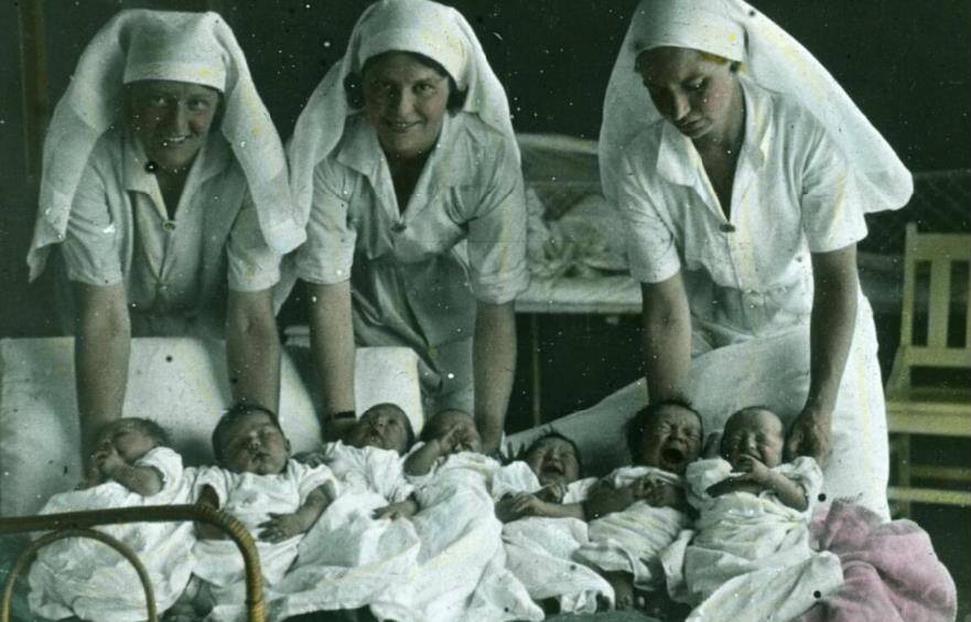 Three unidentified nurses with seven newborn babies in the 1940s. Picture: National Library of Australia.