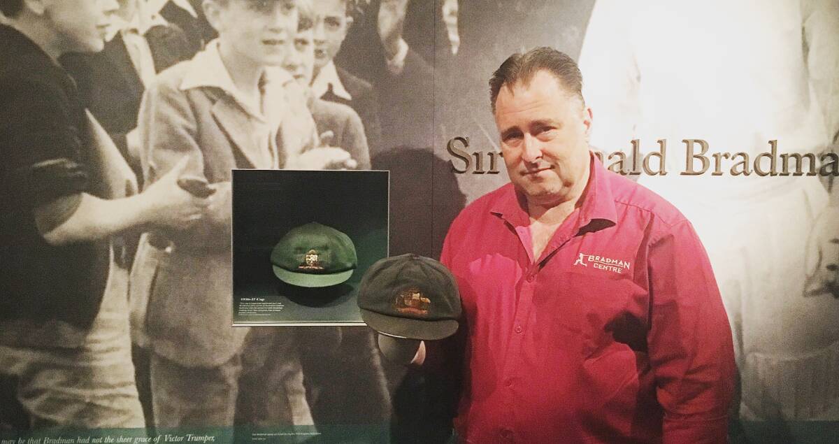 Bradman Museum's curator Andrew Summerell holding Justin Langer's original Test cap next to the great Sir Donald Bradman's baggy green. 