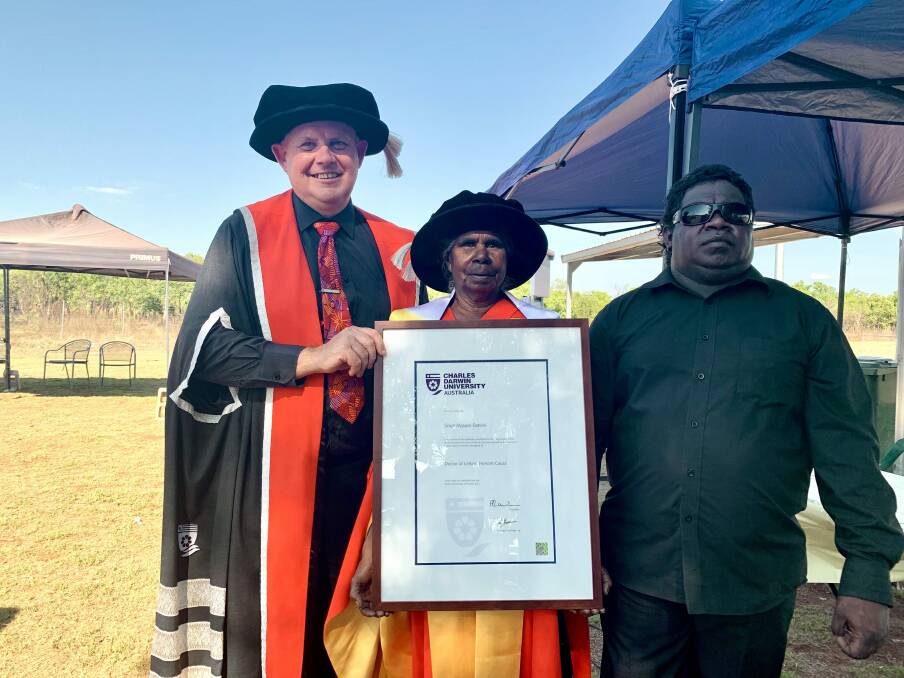 PROUD ELDER: Dr Grace Miguyie Daniels receives an honorary Doctor of Letters from Charles Darwin University at an on-country ceremony in Ngukurr. Picture: supplied.