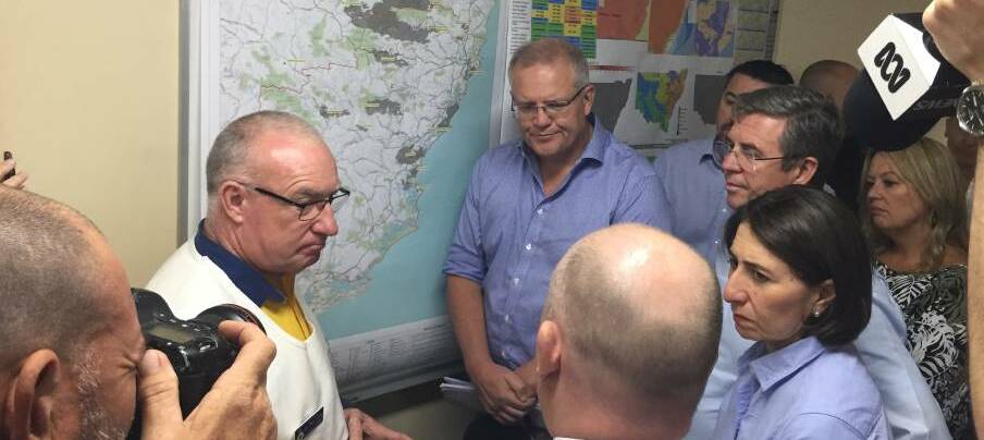 RFS Incident controller Kam Baker briefing Prime Minister Scott Morrison with a slew of pollies and media in Wauchope back in November. Photo: Peter Daniels 