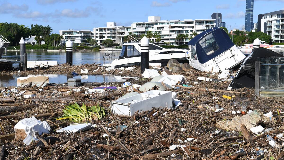 Boats and other debris are seen washed into Hawthorne ferry terminal by the force of the flood waters in Brisbane. Photo: AAP Image/Darren England