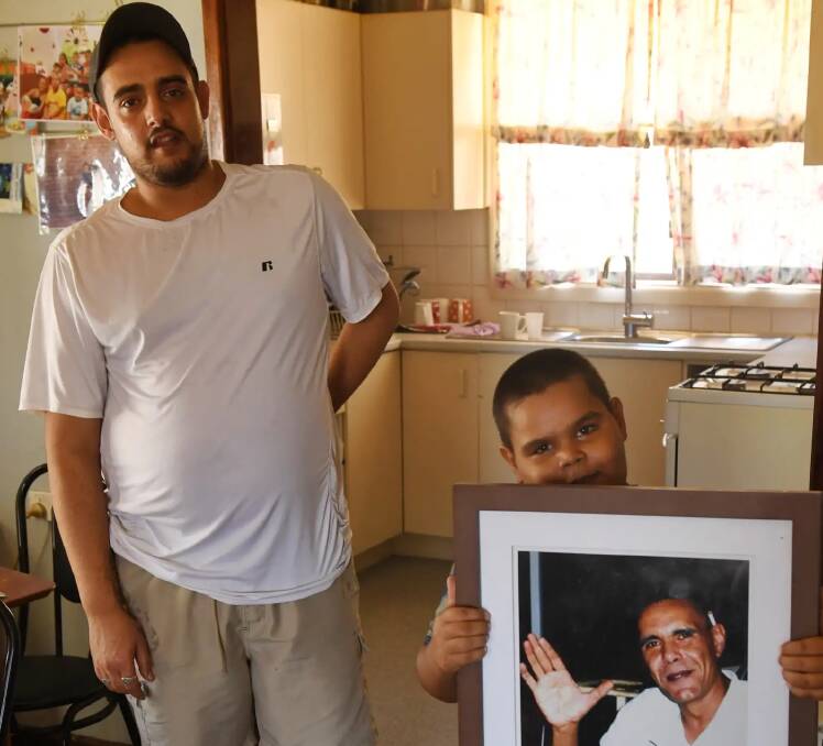 Thomas, 7, holds a photo of his late father. Photo: Nick Moir