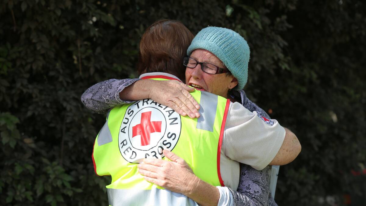 REACH OUT: An emergency worker comforts a survivor. Photo AMELIA WONG, AUSTRALIAN RED CROSS