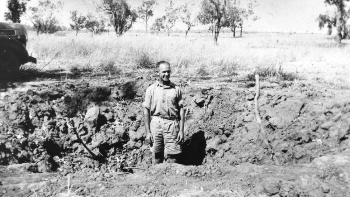 PMG Lineman Jack Corbell stands in a bomb crater. Photo: Katherine Museum. 
