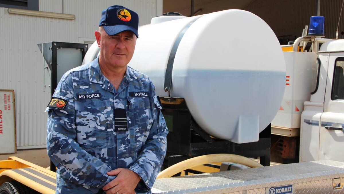 Wing Commander Andrew Tatnall with a small tank of the biodegradable product that is designed to replicate AFFF. Picture: Melody Labinsky