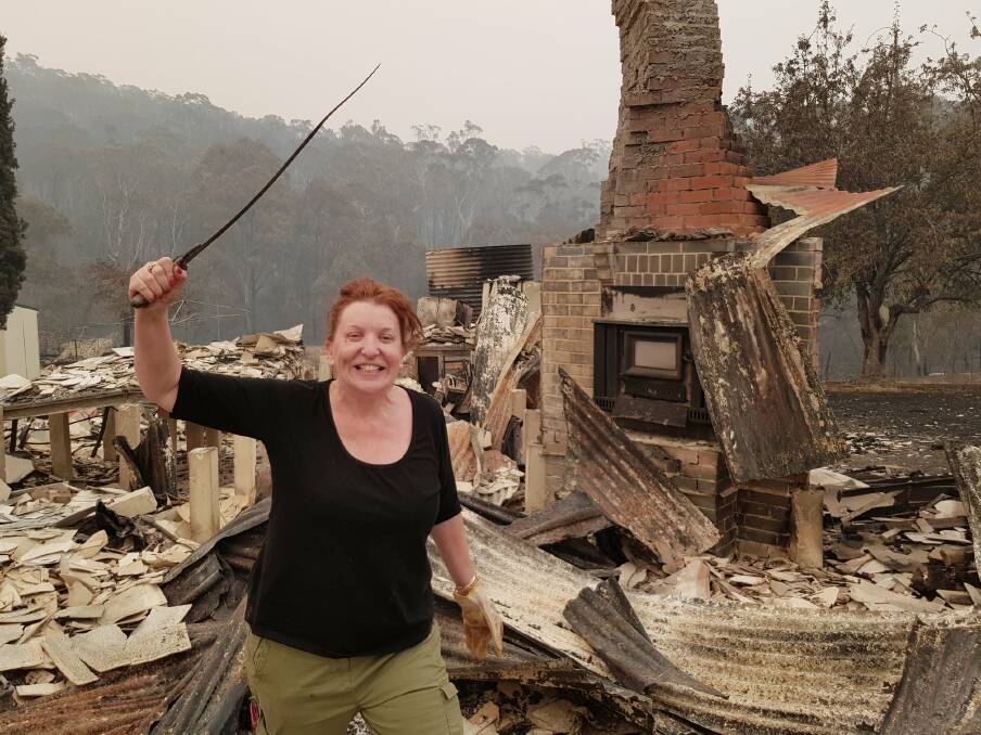 Gemma Pritchard finds an antique sword she received for Christmas in the ruins of her family's Tumbarumba property, which was destroyed by fire on New Year's Eve.