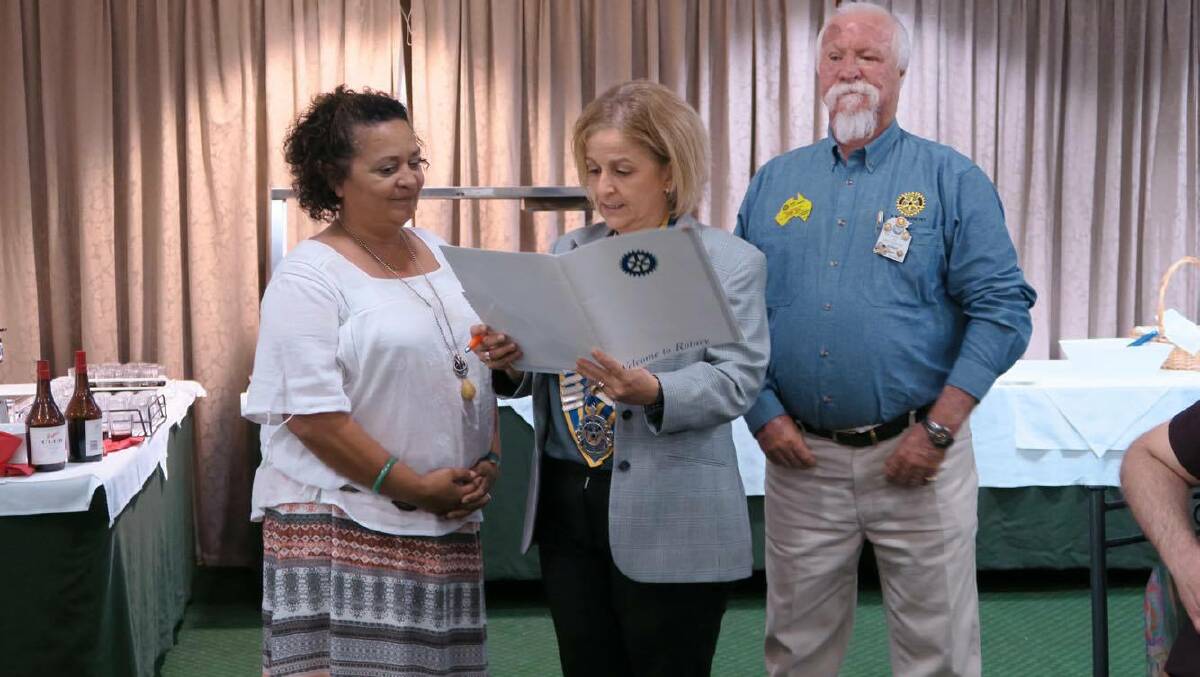 ROTARIANS: Sandra Nelson being inducted in Katherine Rotary by Ida Portella with Rotary president John leo overseeing the moment. 