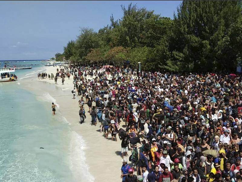 Tourists are fleeing Indonesian resort islands after a strong earthquake on Lombok killed 98 people.