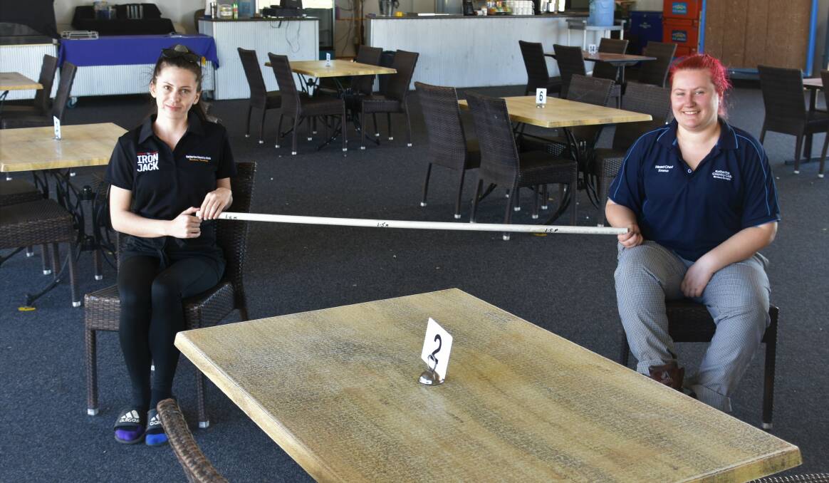 Katherine Country Club employees Rachel Drury and Emma Fitzpatrick kindly illustrate the distance they expect from patrons this Friday.