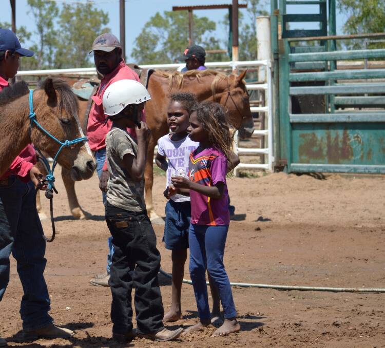 LEARNING THE ROPES: Borroloola youth Lawrence Johnston, 8, Quartaya Miller, 7,
and Rickeisha Rory, 7, discuss the finer points of horsemanship in the middle of the
town’s rodeo arena during the Great Borroloola Cattle Workshop. Picture: supplied. 