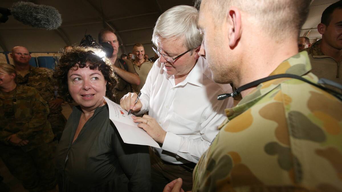 Prime Minister Kevin Rudd, with his wife Therese Rein, signs a get well soon card for an Australian soldier. Photo: Gary Ramage/pool