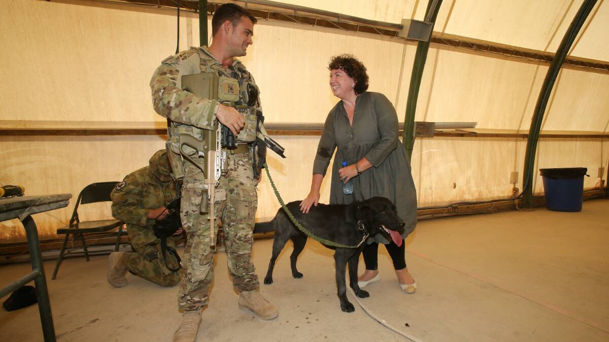 Therese Rein chats with Sapper Rob Muraru and his explosive detection dog, Shuba, in Tarin Kowt, Uruzgan province southern Afghanistan. Photo: Gary Ramage/Pool